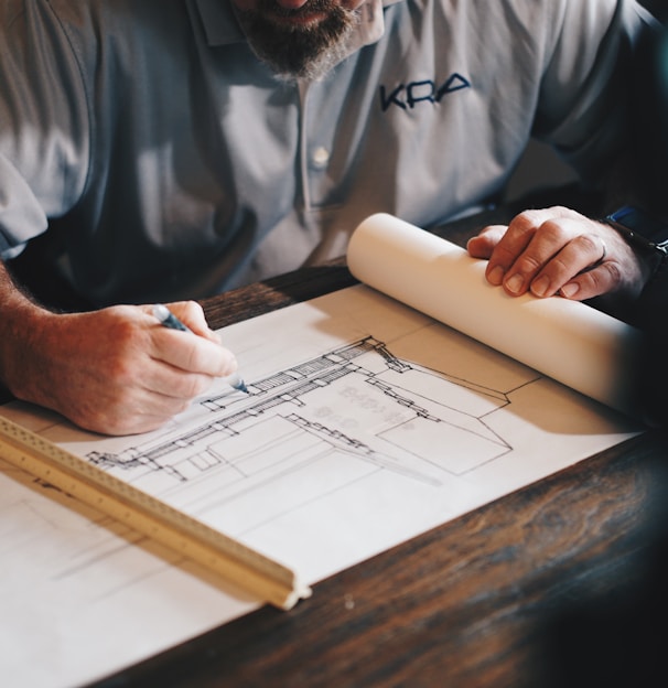 An architect working on a draft with a pencil and ruler