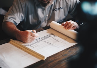 An architect working on a draft with a pencil and ruler