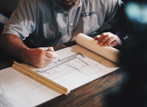 An architect working on a draft with a pencil and ruler