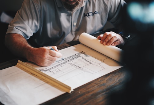 An architect working on a draft with a pencil and ruler