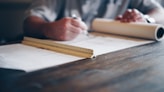person drafting on blueprint
