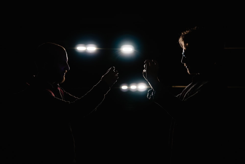 two men facing each other in a dark room
