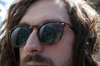 Close-up of a Roblox character sporting reflective, angular sunglasses with a subtle glow.