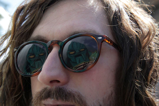 Close-up of a Roblox character sporting reflective, angular sunglasses with a subtle glow.