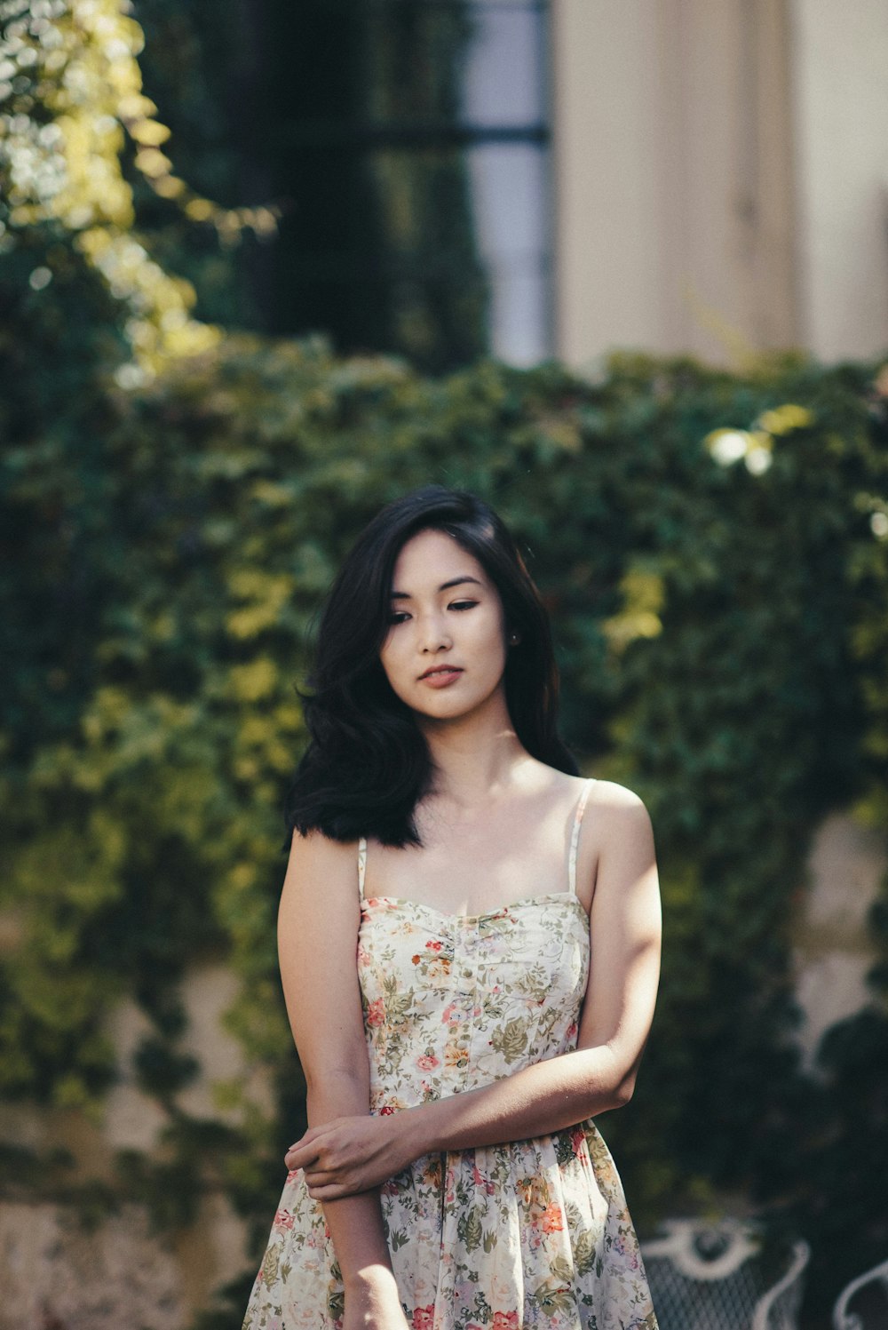 woman standing in front of wall covered by plants