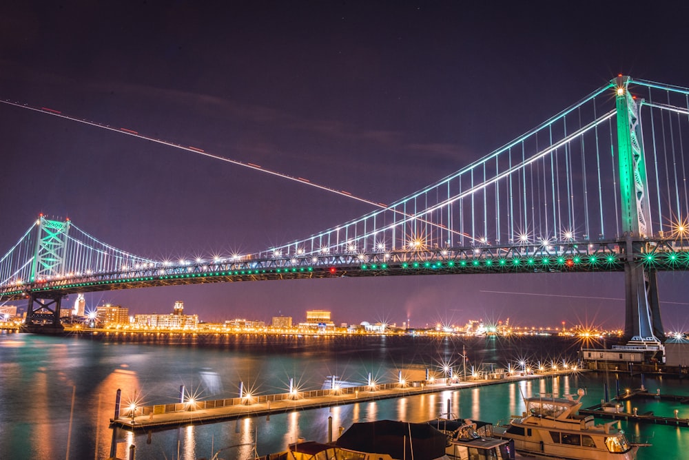 suspension bridge with string lights at nighttime
