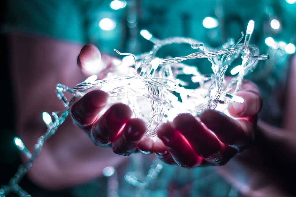 person holding string lights