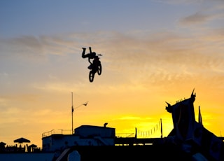 silhouette of person riding motocross dirt bike