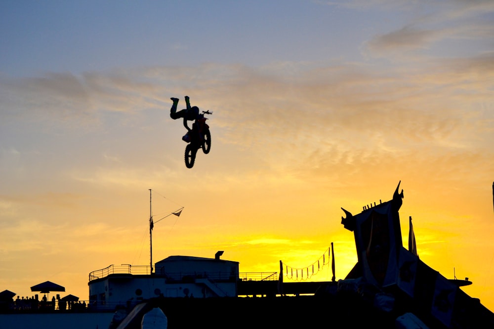 Silhouette einer Person, die Motocross-Dirtbike fährt