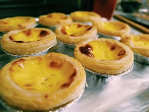 Crispy pastel de nata with a caramelized top, steaming fresh from the oven