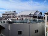 A community center with a curved roof and expansive glass walls blending into the surrounding park.