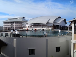 A community center with a curved roof and expansive glass walls blending into the surrounding park.