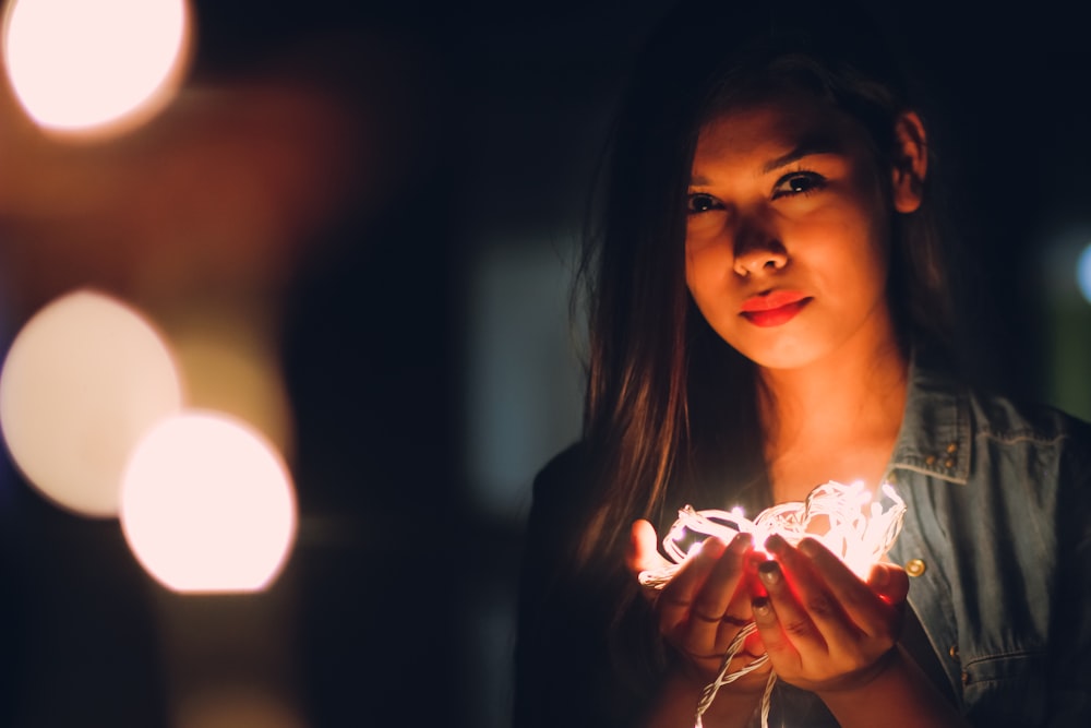 woman holding white string lights