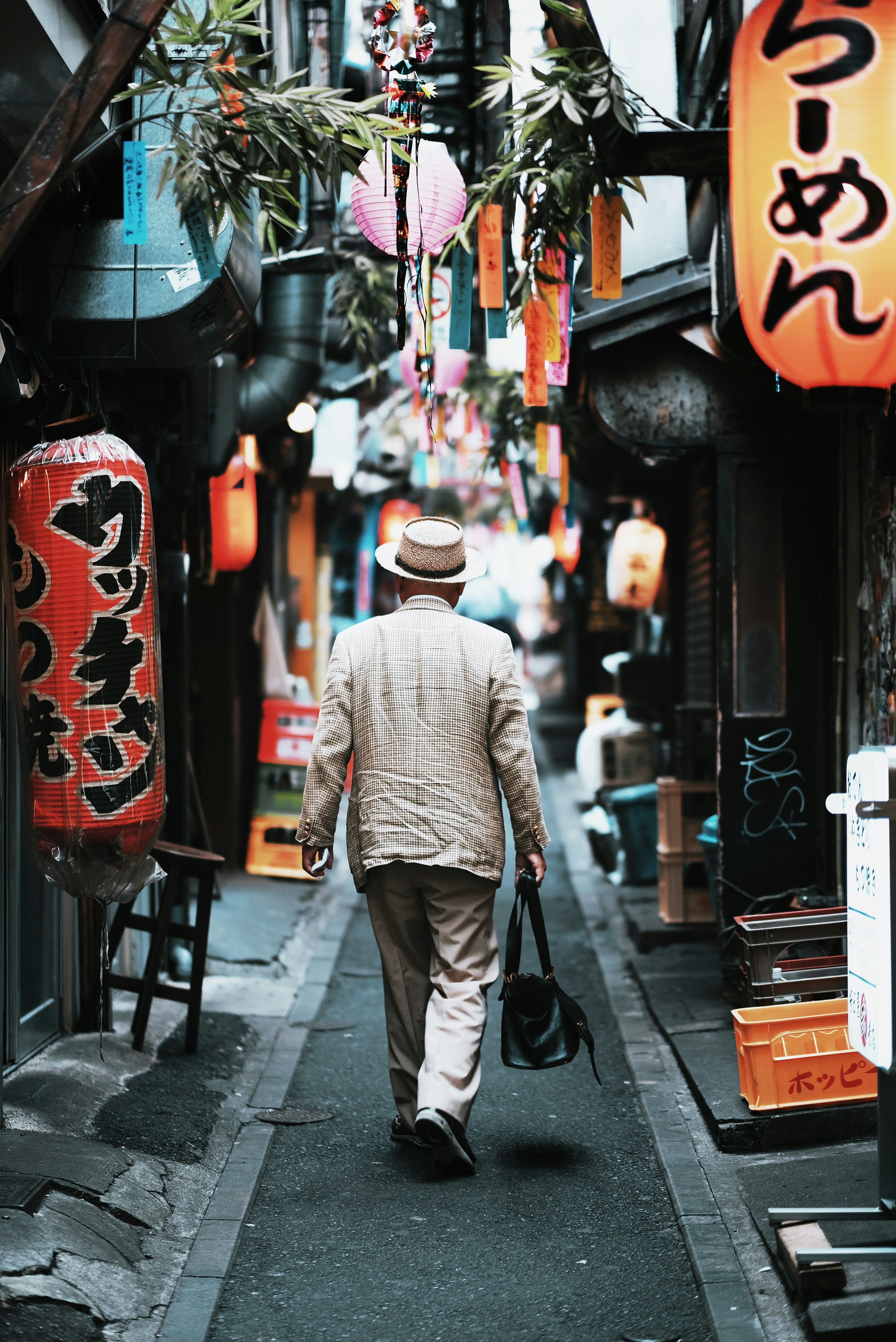 An elderly man in a suit in a narrow alley in Tokyo's Shinjuku district