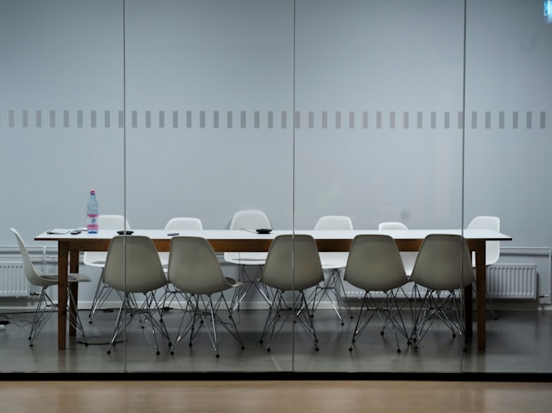 Sanitizing high-touch surfaces in a modern conference room with disinfectant spray.