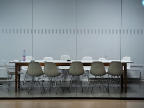 A team member carefully sanitizing high-touch surfaces in a modern conference room.