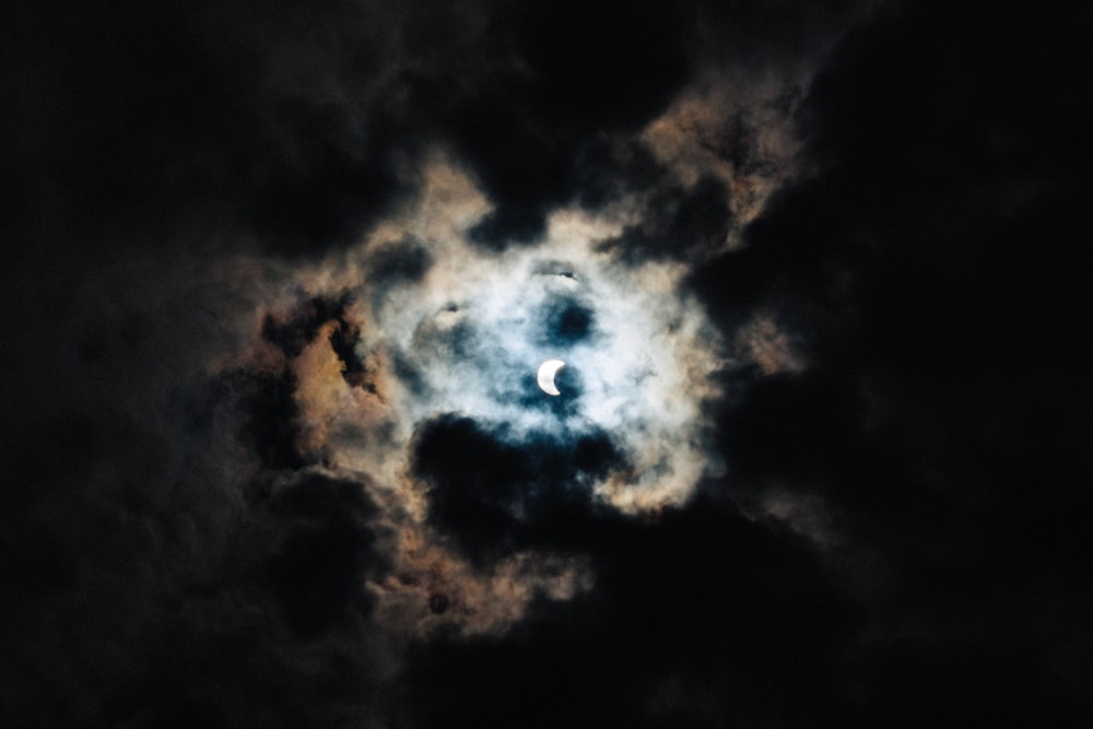 crescent moon behind black clouds