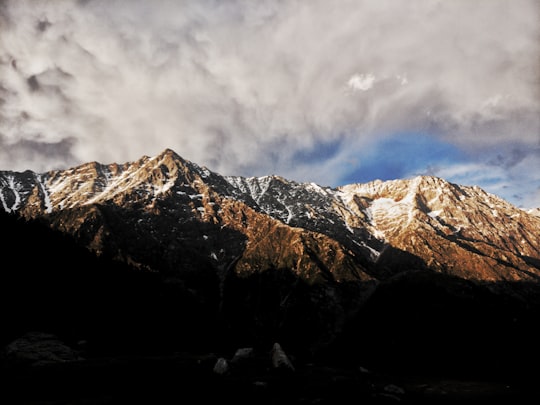 mountain ranges under cloudy sky during daytime in Triund India