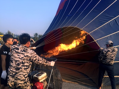 An instructor guiding a small group through hands-on hot air balloon maintenance training outdoors.