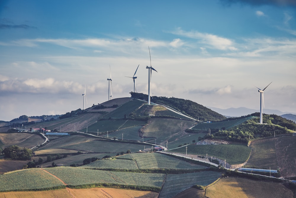 white windmills on top of mountain at daytime