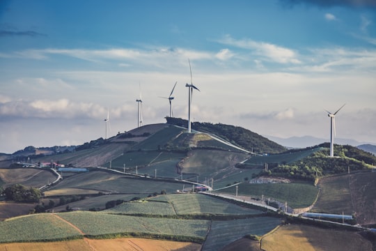 white windmills on top of mountain at daytime in Pyeongchang-gun South Korea