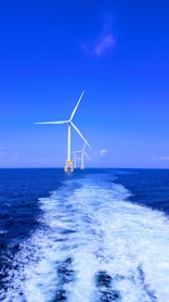 three white wind turbine on sea