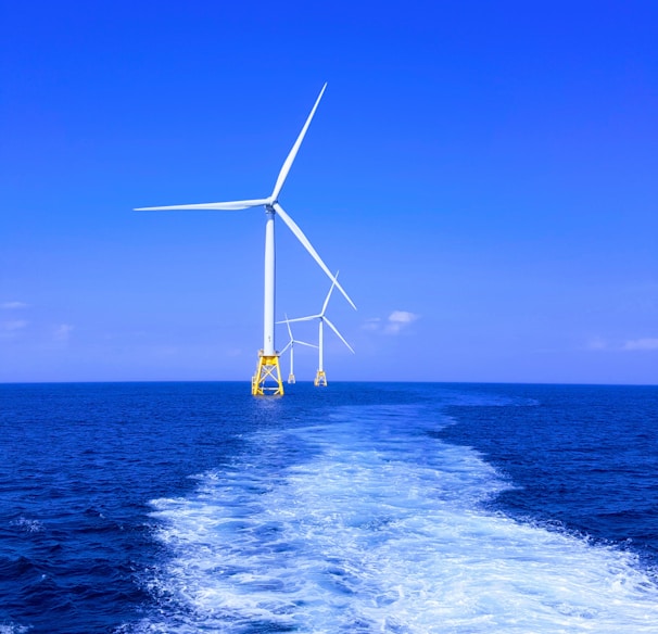 three white wind turbine on sea