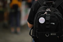 Close-up of a sleek black backpack with multiple compartments open, showcasing organization.