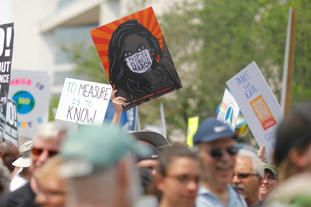 people gather holding banners protesting near building