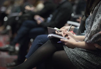 Close-up of hands writing notes during a professional training session.