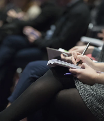Close-up of hands writing notes during a professional training session.