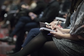 Close-up of hands taking notes during a personal development seminar.