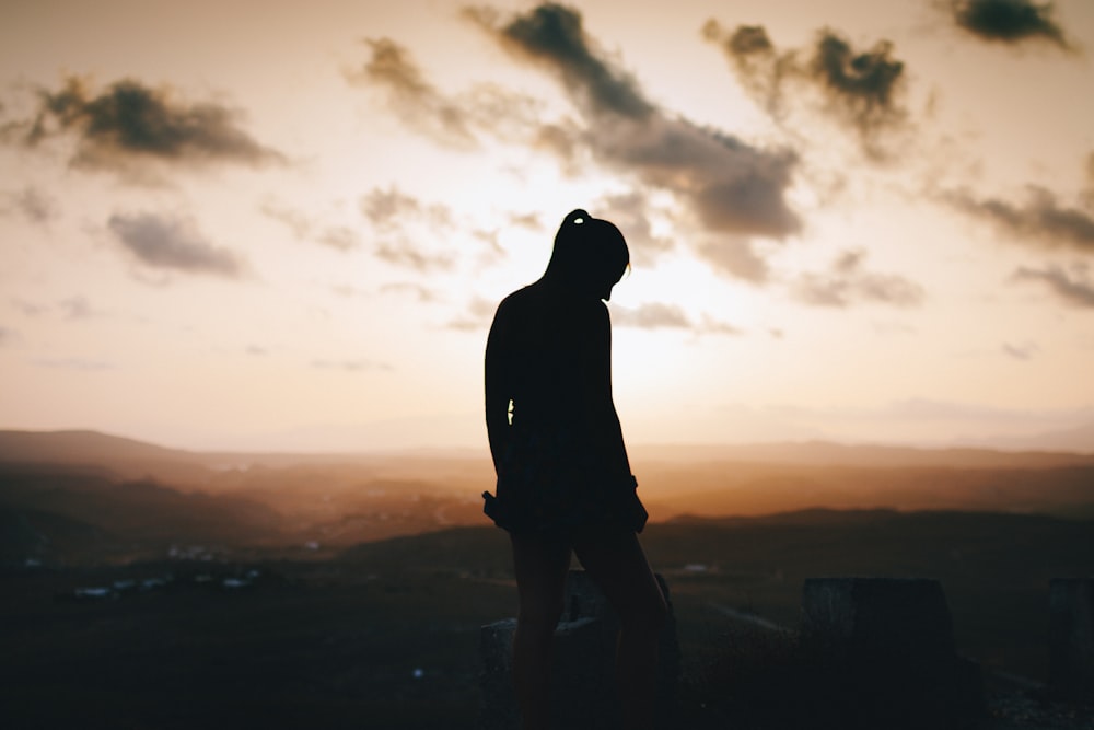 silhouette of woman standing near field