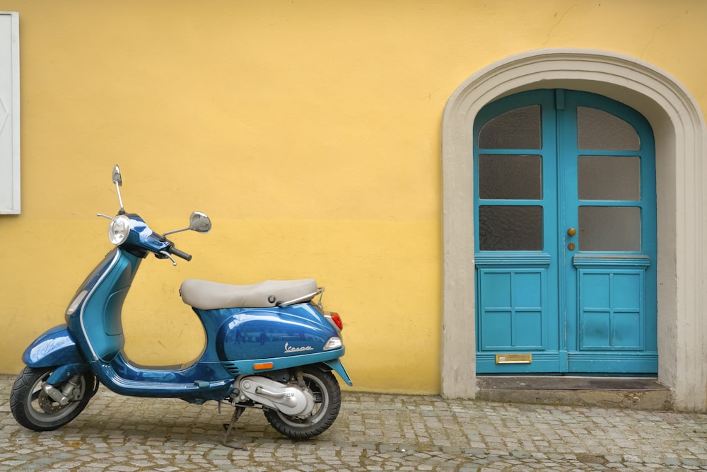 motocicleta scooter azul fuera de la casa