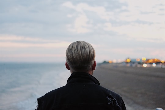 man in black coat walking on seashore in South Parade Pier United Kingdom