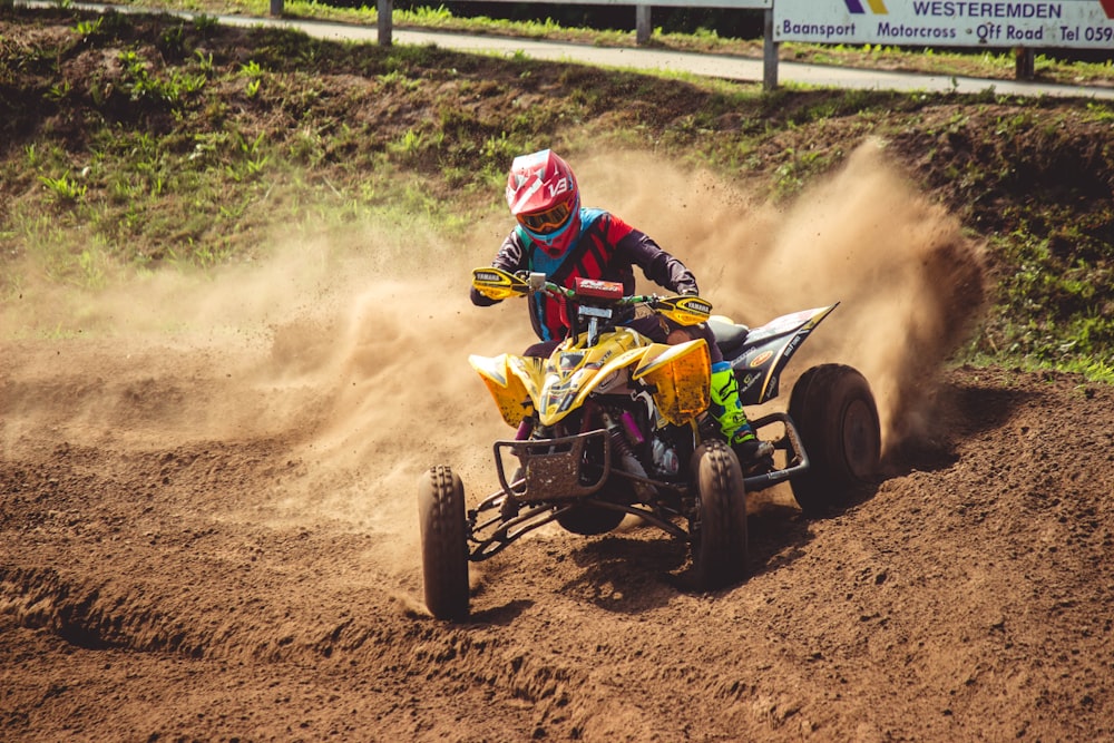 man ridding yellow and black ATV