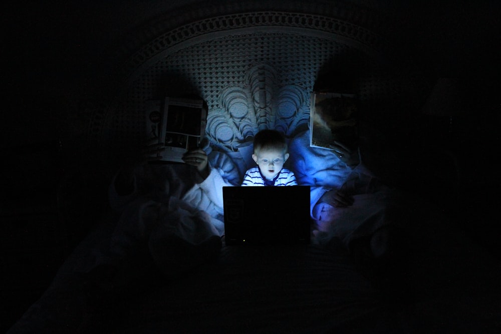 menino brincando no laptop dentro do quarto