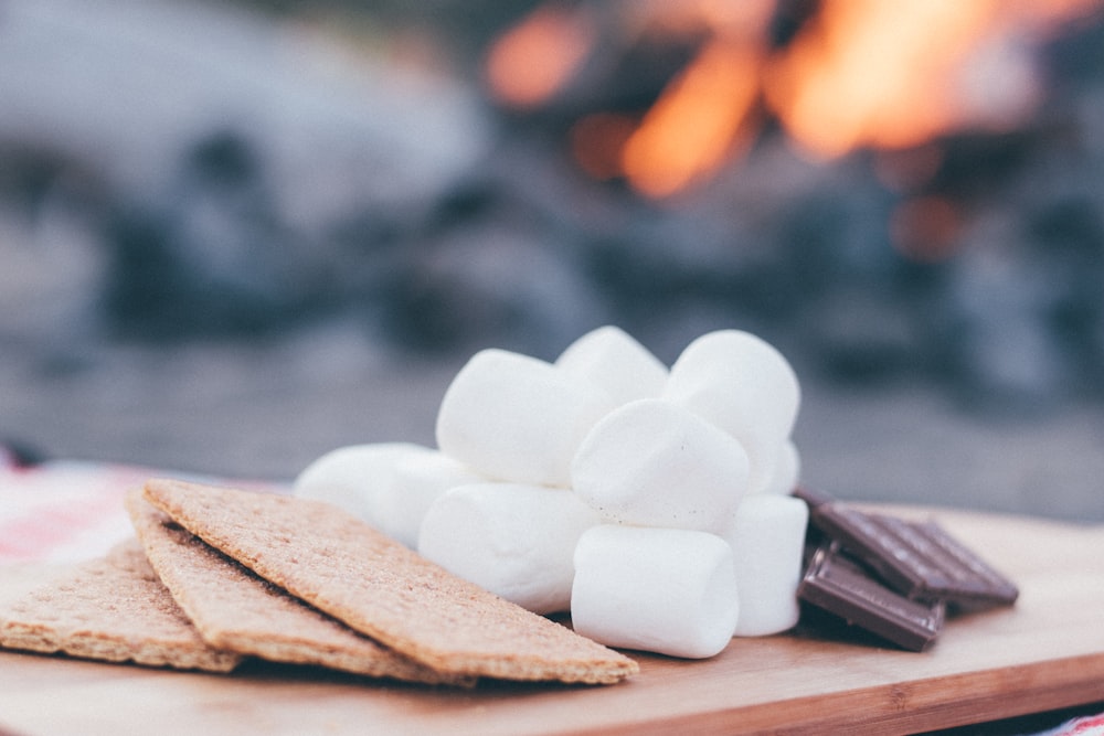 biscuits, marshamallows et tablettes de chocolat sur plateau en bois