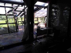 A serene studio space with a guzheng set up beside a window overlooking a garden.