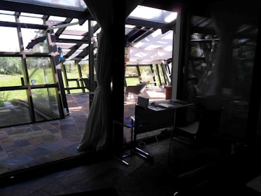 A serene studio space with a guzheng set up beside a window overlooking a garden.