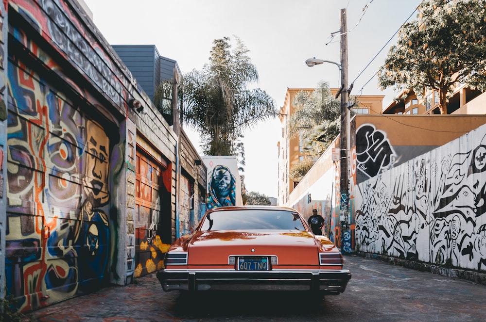 orange car parked between painted walls