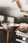 person garnishing on gray stainless steel bowl