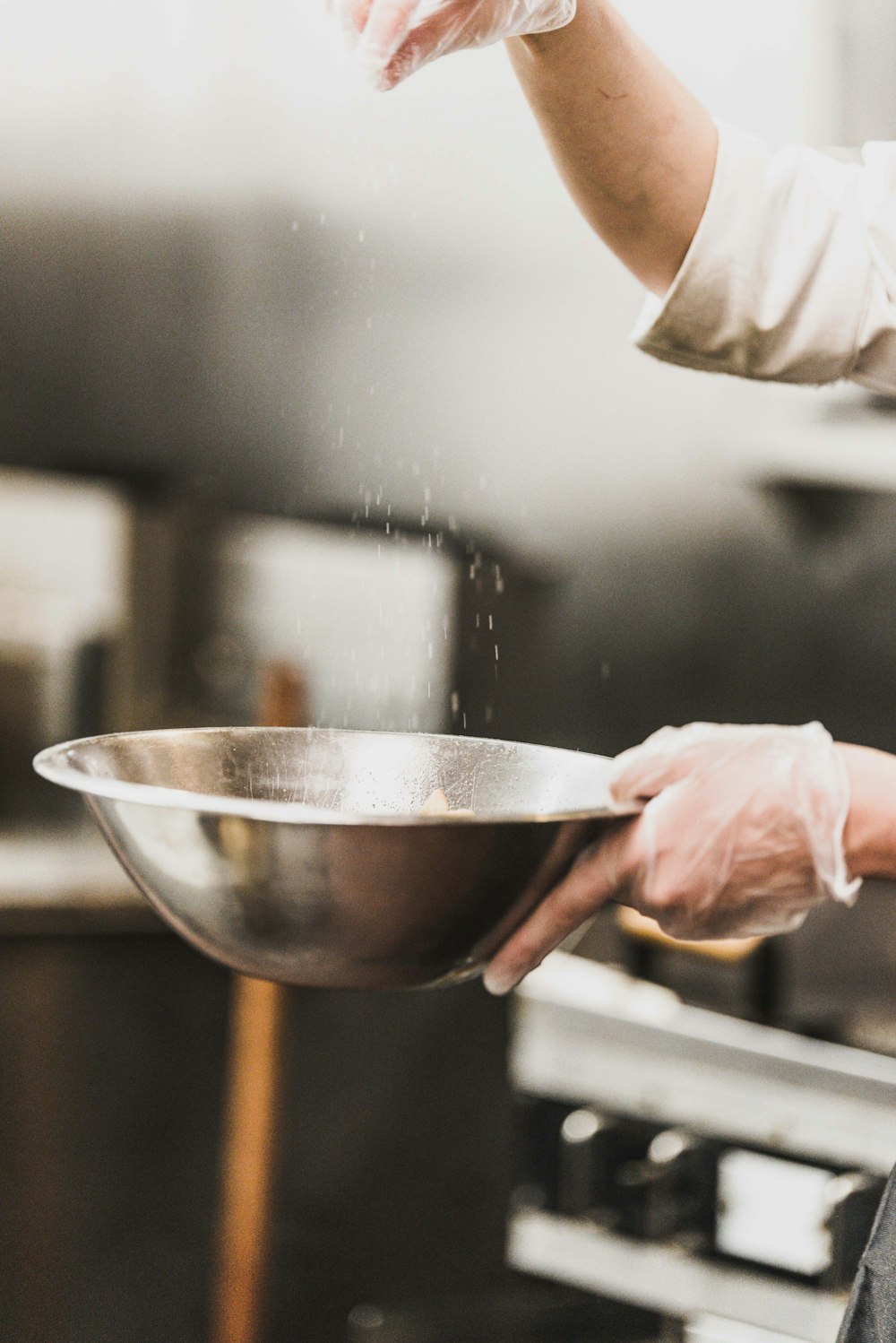 person garnishing on gray stainless steel bowl