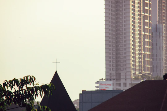 A pastor delivering a sermon with the Fukuoka skyline softly glowing behind him.