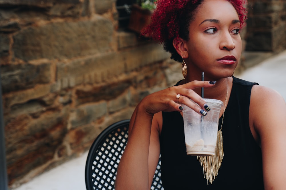 woman drinking on clear plastic cup