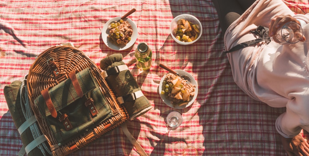 Cesta de picnic de mimbre marrón sobre textil rojo