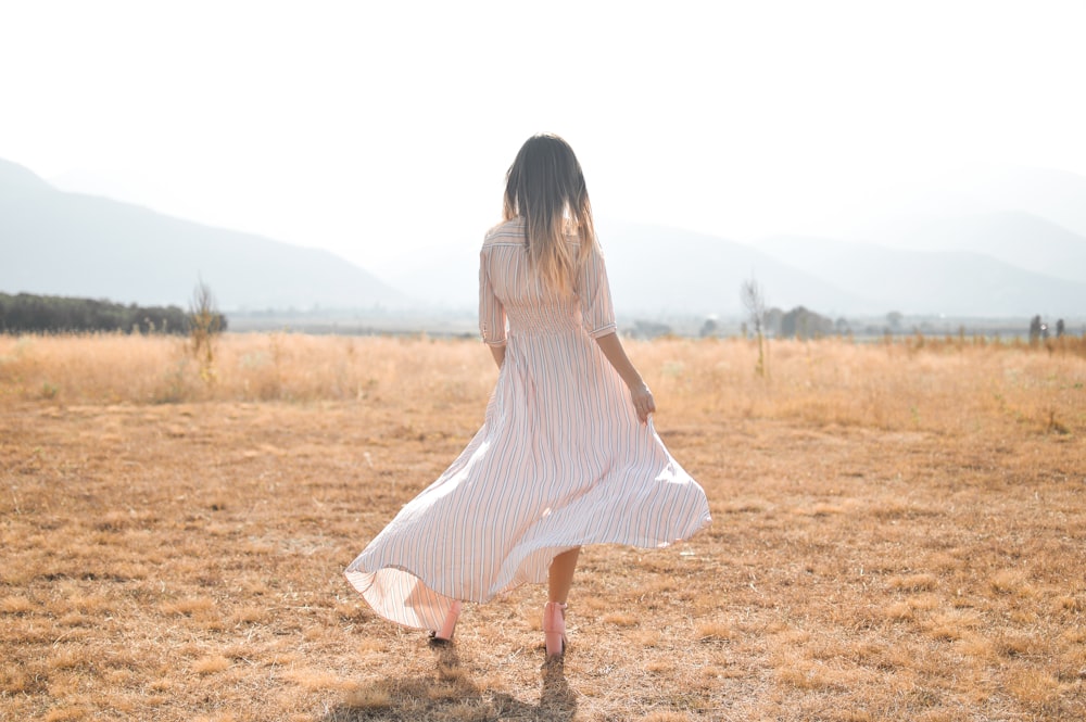 Mujer de pie en un campo marrón llano
