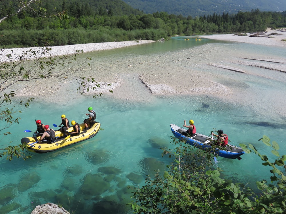 two groups of people riding on yellow and blue kayaks