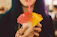Smiling woman holding a tropical drink with a colorful beach backdrop.