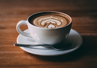 white ceramic teacup with coffee latte art